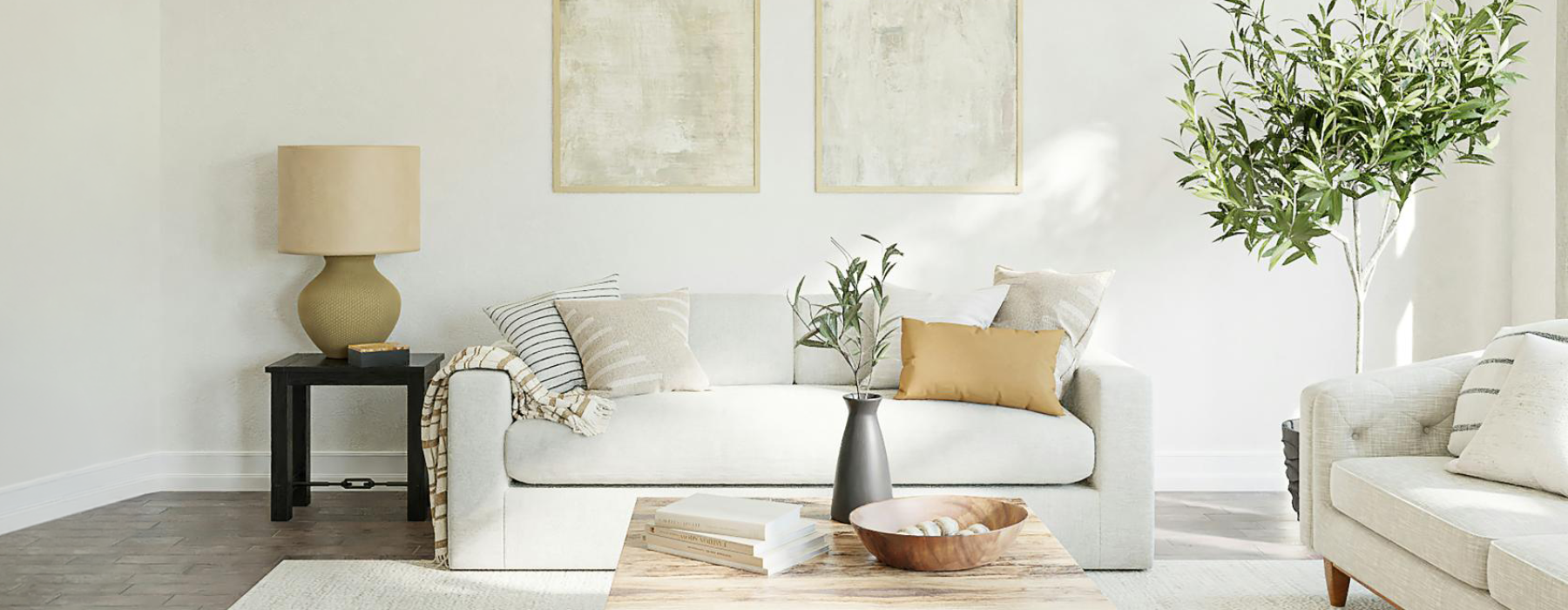 a living room with a white couch and a white wall with art on it