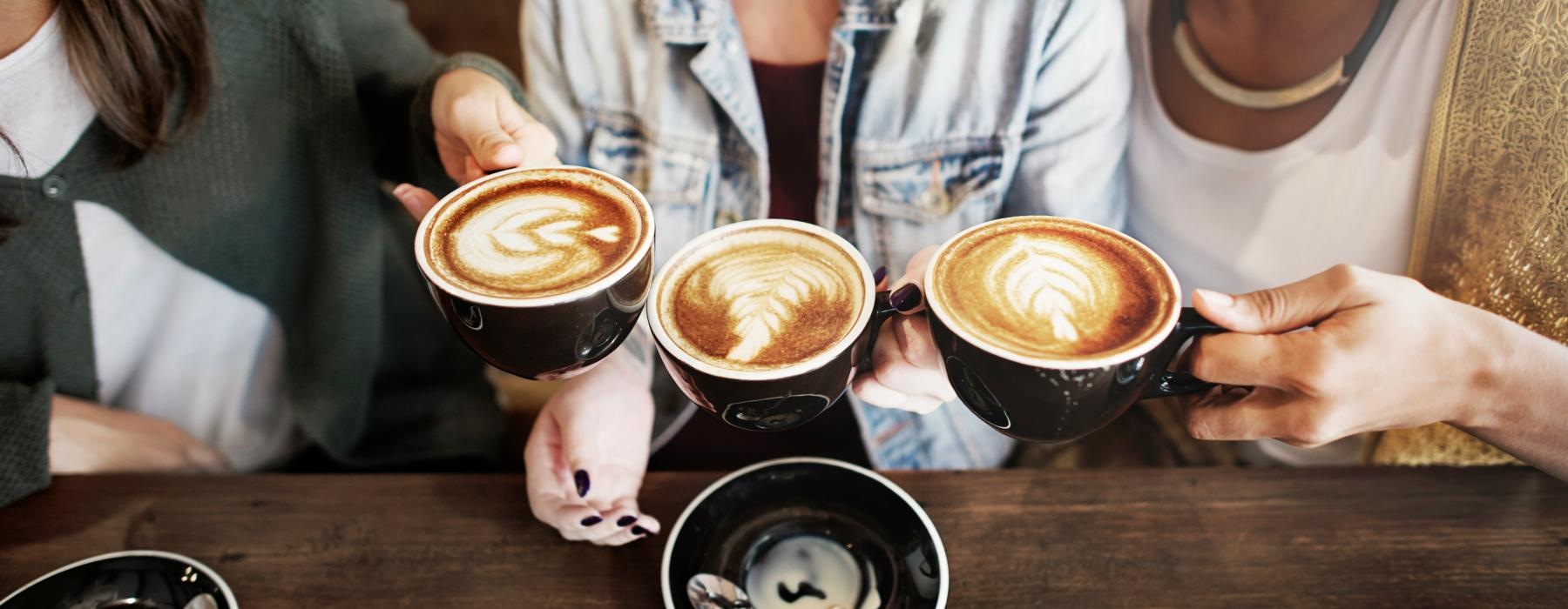 a group of people holding cups of coffee